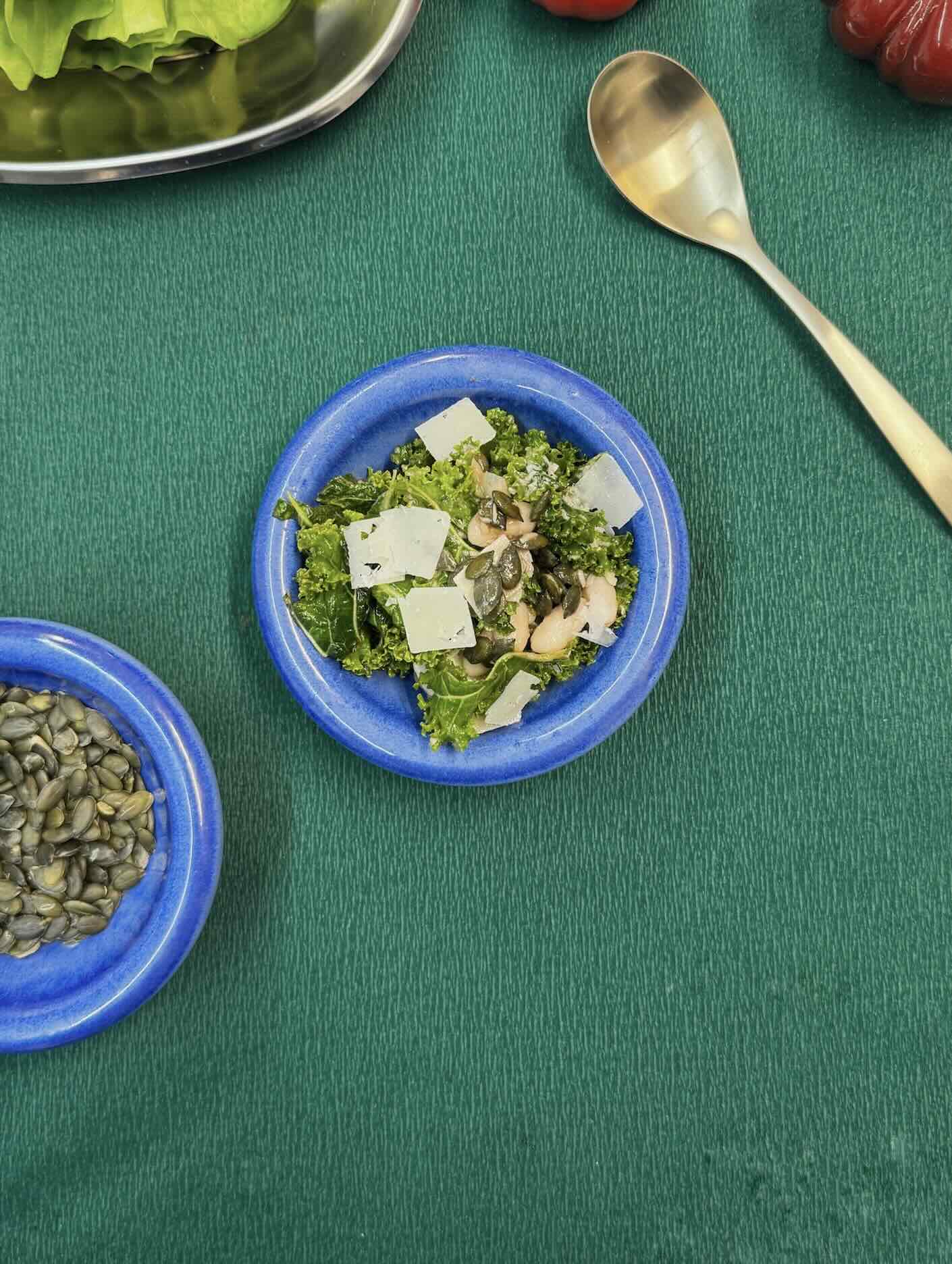 Ensalada de kale, achicoria y alubia blanca con pipas de calabaza y queso curado